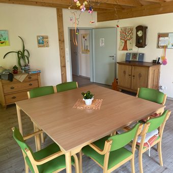 Wohnbereich Heller Raum mit einer Holzdecke und einem großen Holztisch mit Stühlen