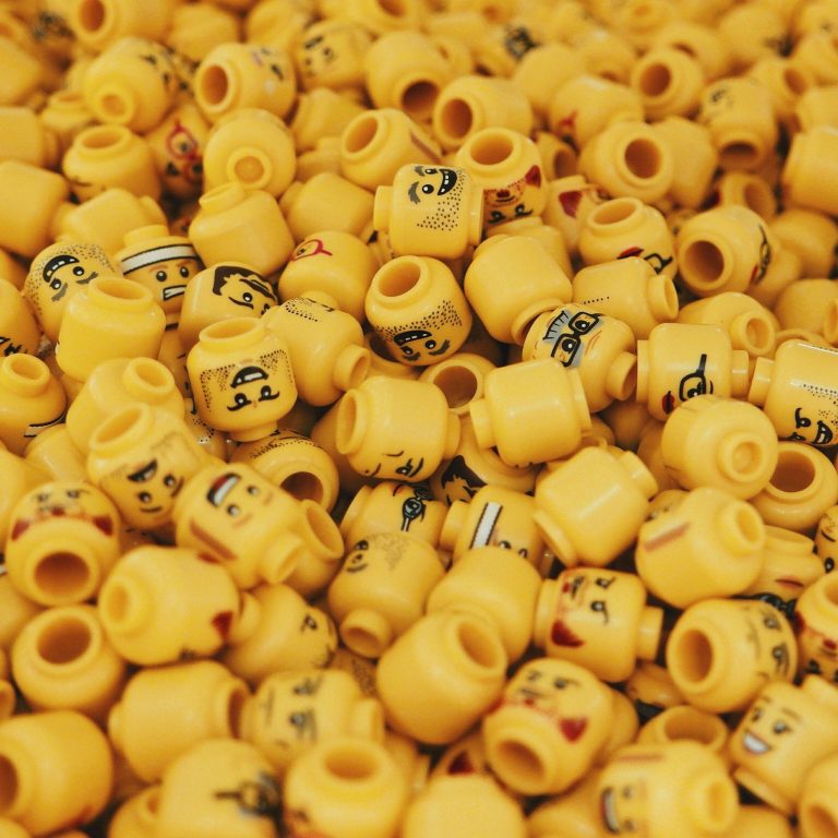 Viele Gesichter Eine Ansammlung gelber Lego-Köpfe mit verschiedenen Gesichtern und Ausdrucksformen.