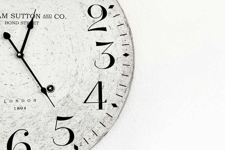 Weiße vintage Wanduhr mit großen Zahlen und einem minimalistischen Design.