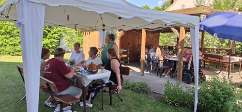 Gesellschaft Erdbeerfest Menschen sitzen unter einem Zelt und genießen eine gesellige Runde im Freien.